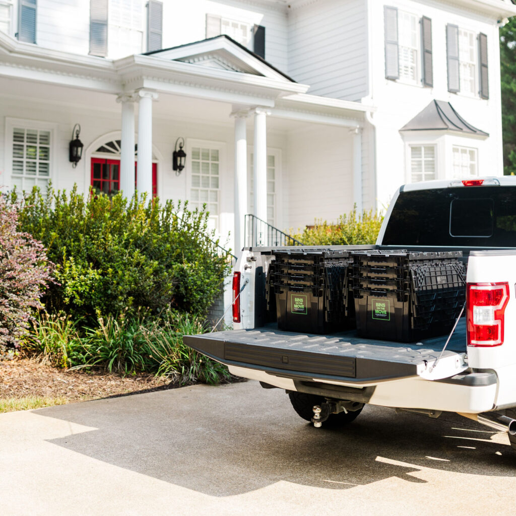 Reusable moving boxes in the back of pickup truck.